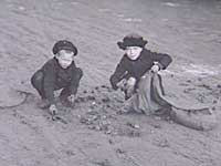 Børn samler kulstykker på havnen