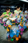 Industriarbejde i dag. Billede af asiatiske kvinder, som sidder og maler farverige pyntegenstande.